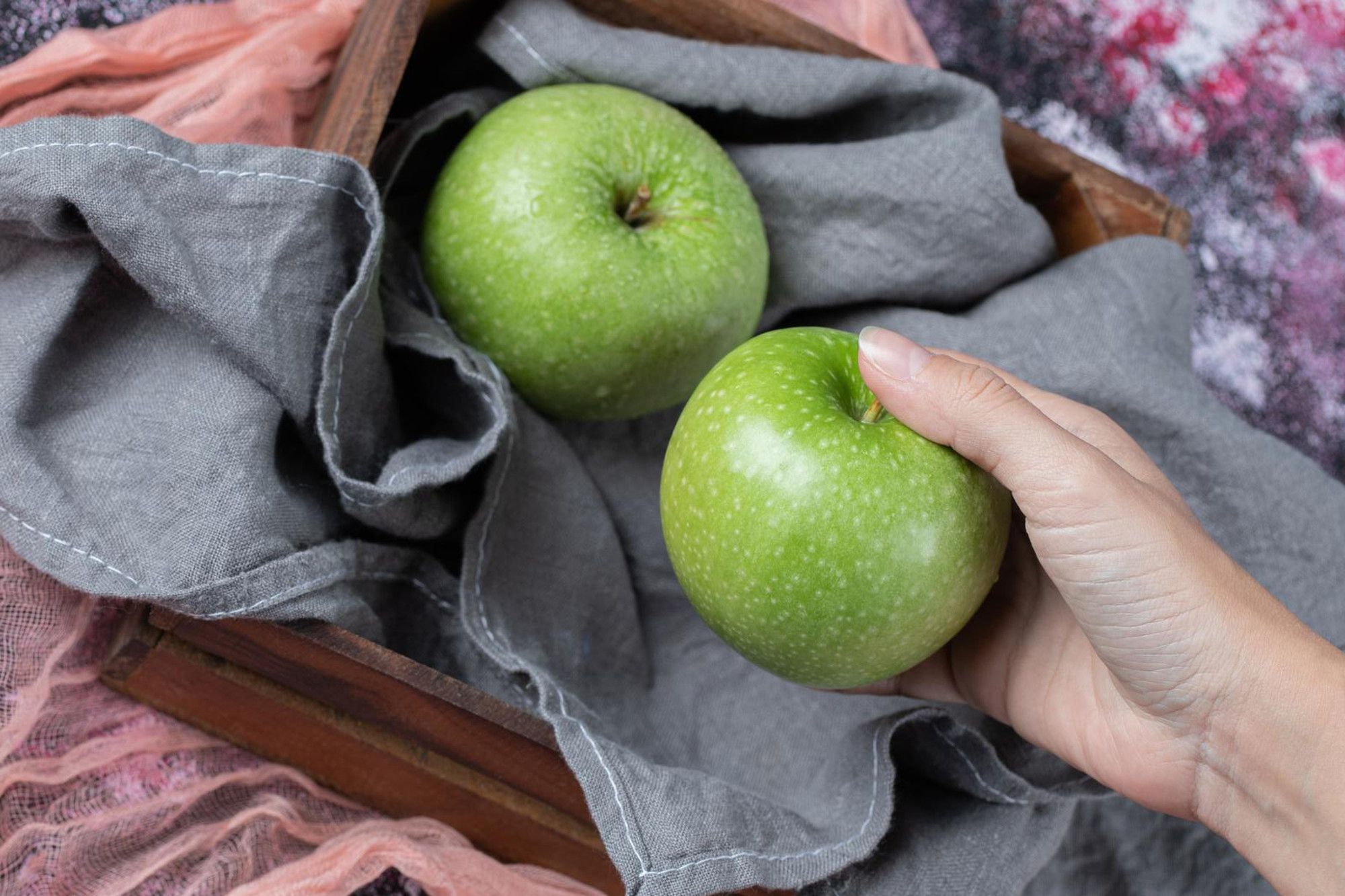 Green Granny Smith apples in a wooden box